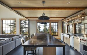 A long marble island site in a luminous kitchen. 